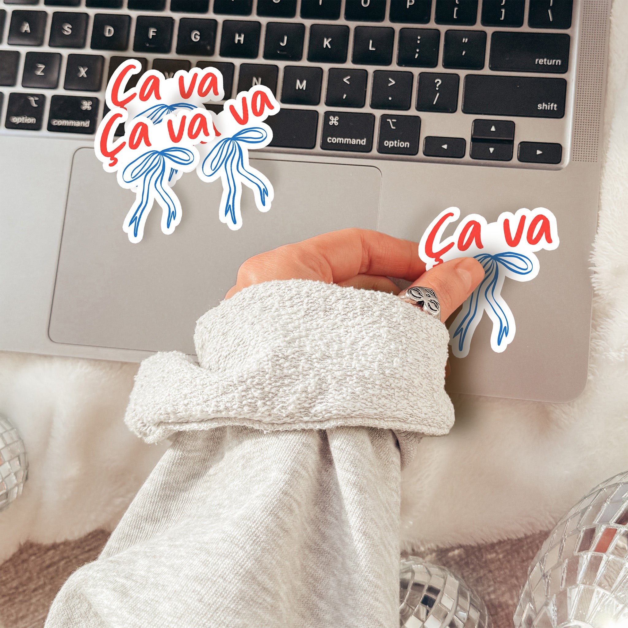 Person wearing a robe with a laptop on a bed, surrounded by 'Ca va' text and graphics.