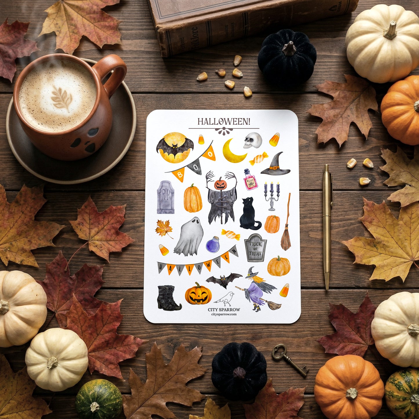 Halloween-themed sticker sheet on a wooden surface with pumpkins, leaves, and a cup of coffee.