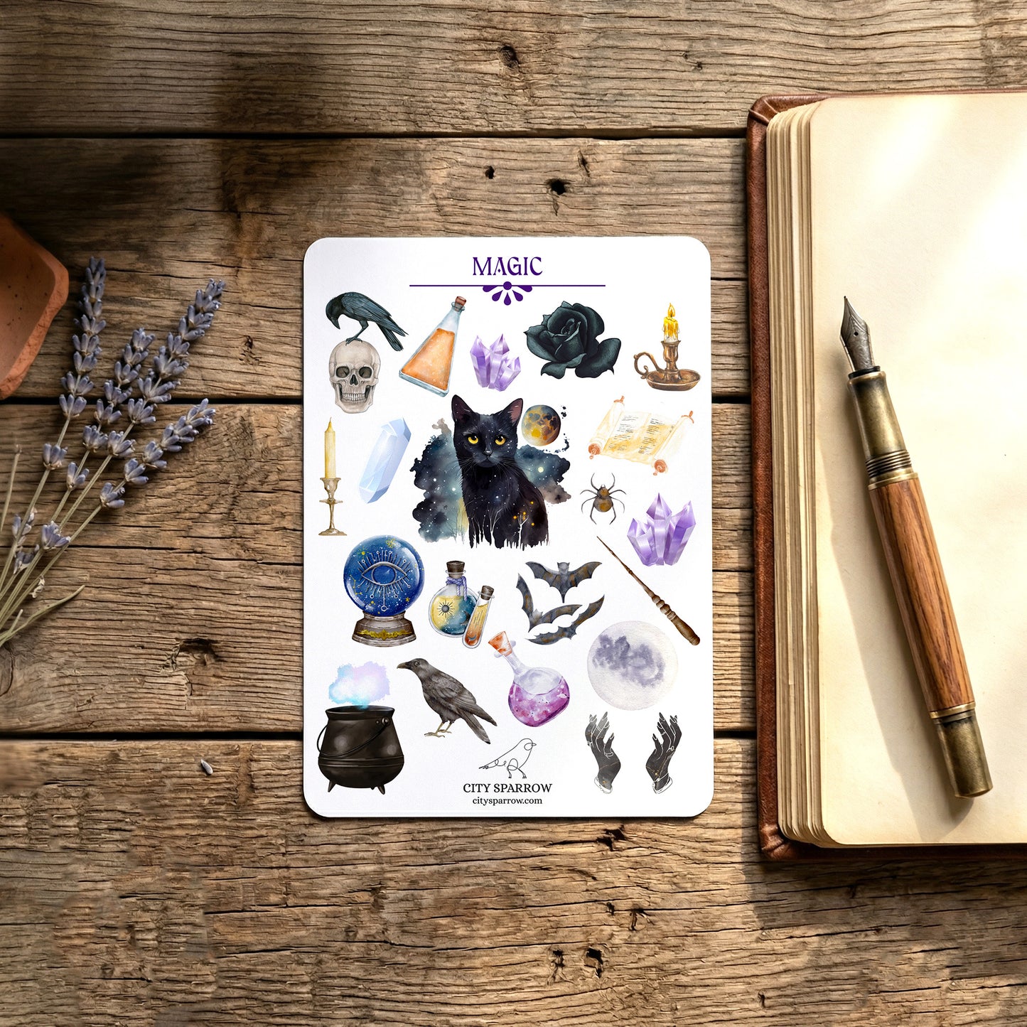 Sheet of stickers with mystical designs on a wooden surface next to an open book and pen.