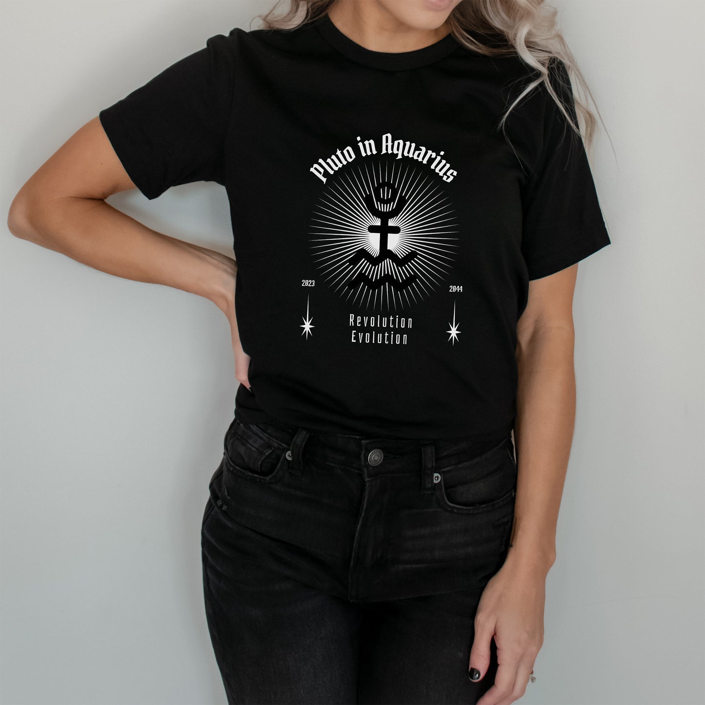Person wearing a black t-shirt with white astrologic graphic design and text against a plain background