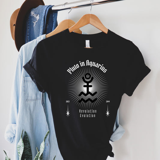 Black t-shirt with astrological design on a hanger with jeans and a hat in the background