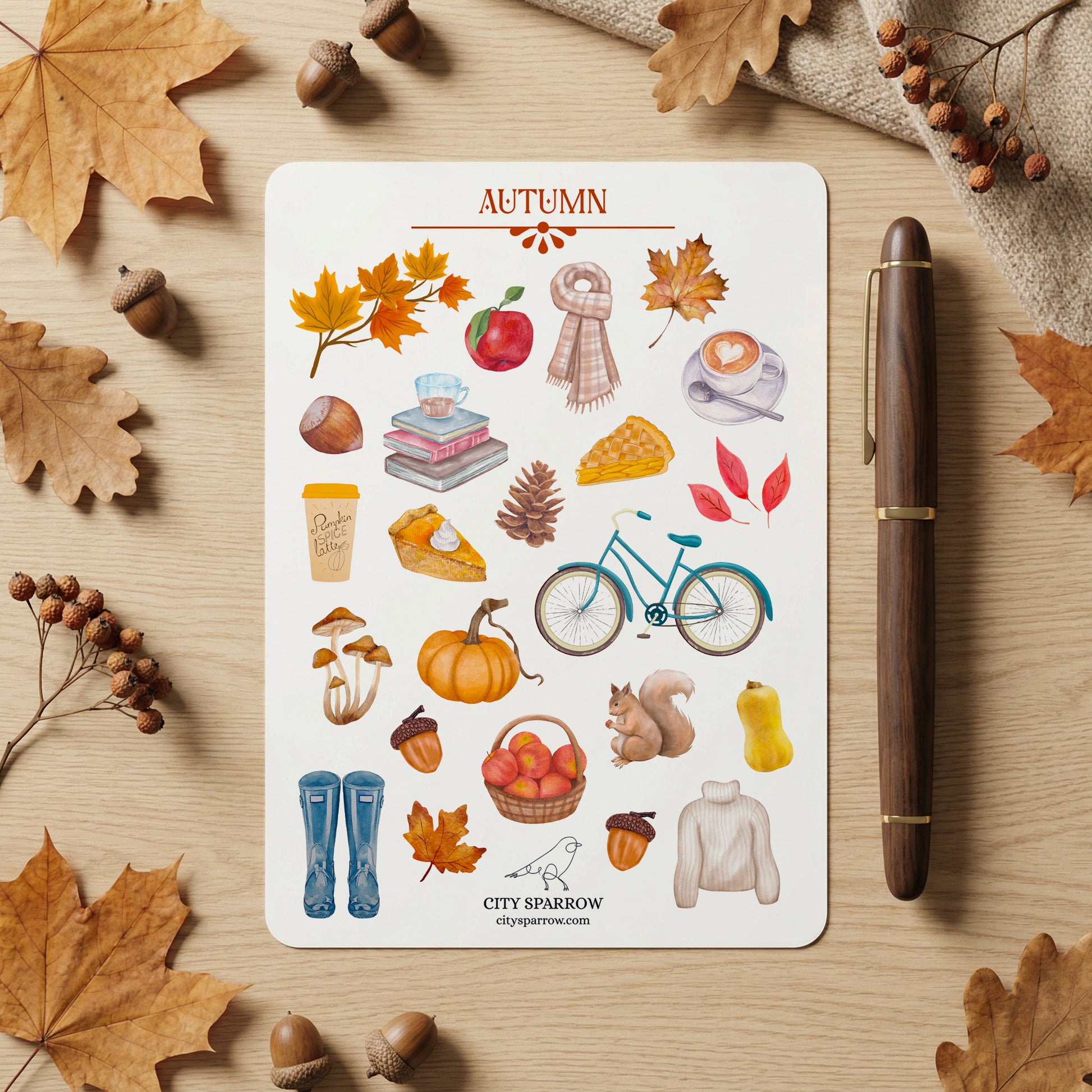 Autumn-themed sticker sheet with a pen and fall leaves on a wooden surface