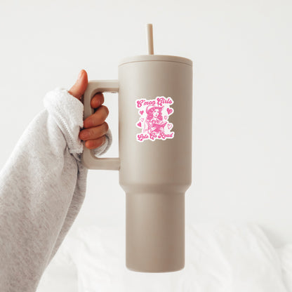 Beige travel mug with a sticker with a pink graphic design of a cowgirl that says C'mon girls, let's go read held by a person on a white background