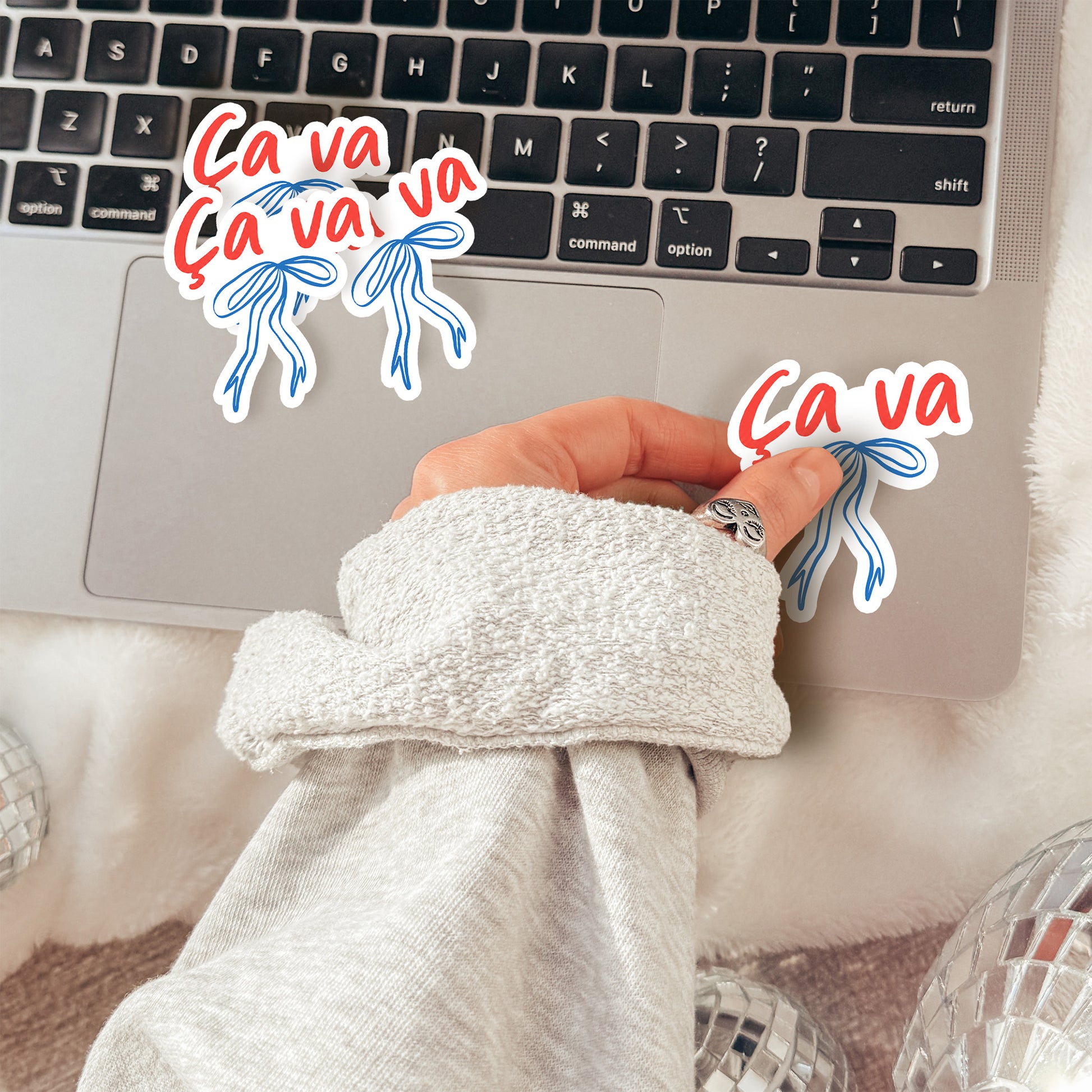 Person wearing a robe with a laptop on a bed, surrounded by 'Ca va' text and graphics.