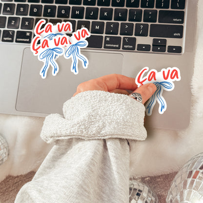 Person wearing a robe with a laptop on a bed, surrounded by 'Ca va' text and graphics.