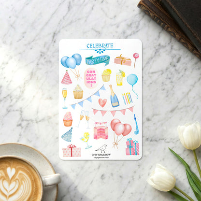 Sticker sheet with party-themed designs on a marble surface with a coffee cup and tulips.