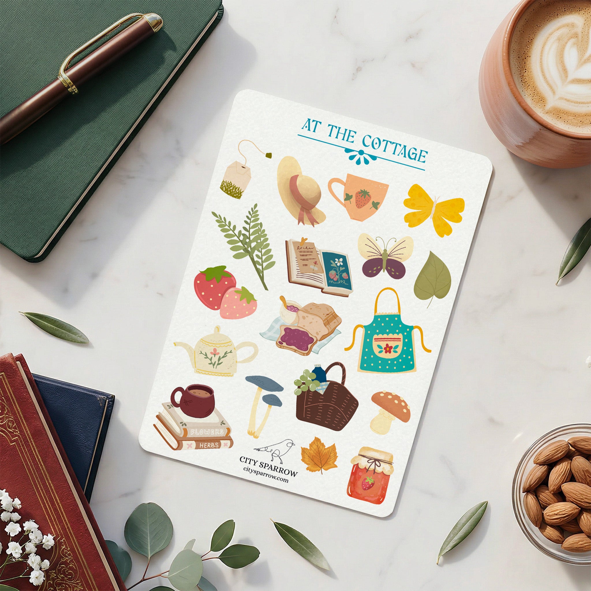 Sheet of stickers with cottage themed  illustrations on a marble surface with a cup of coffee and books.
