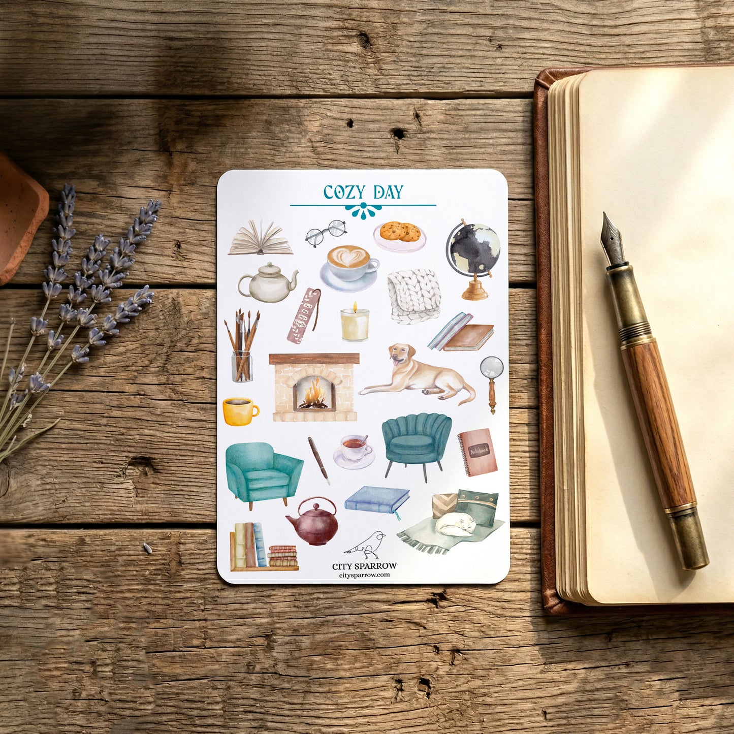 Sheet of 'Cozy Day' themed stickers on a wooden surface with a notebook and pen.