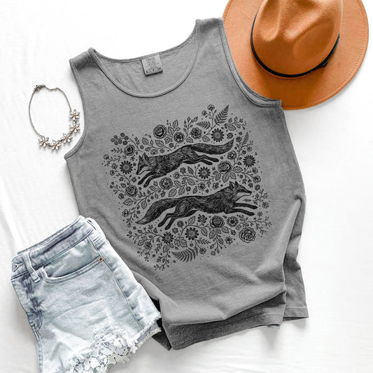 Gray tank top with fox and floral design, paired with denim shorts, a hat, and necklace on a white background.