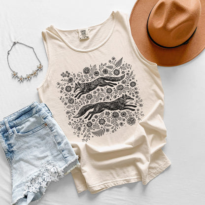 Beige tank top with fox and floral design, paired with denim shorts, a hat, and necklace on a light background.