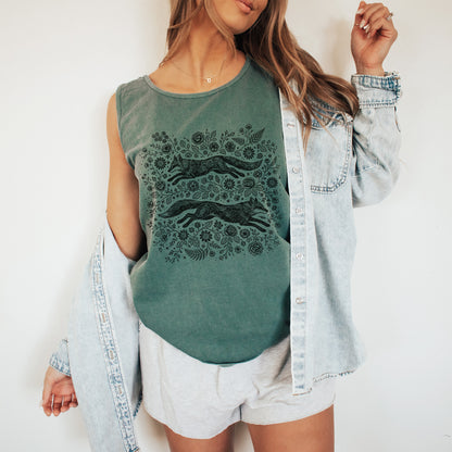 Woman wearing a green sleeveless top with a fox design, white shorts, and a denim jacket on a white background