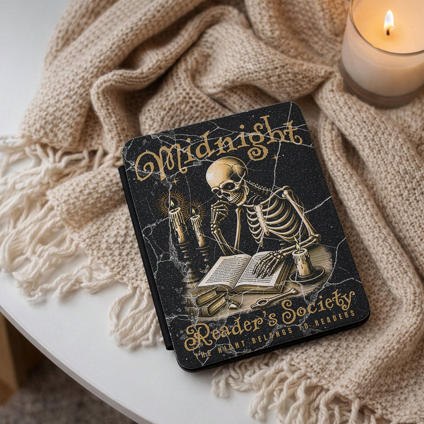 Kindle case 'Midnight Reader's Society' with a skeleton illustration on a textured surface with a candle.