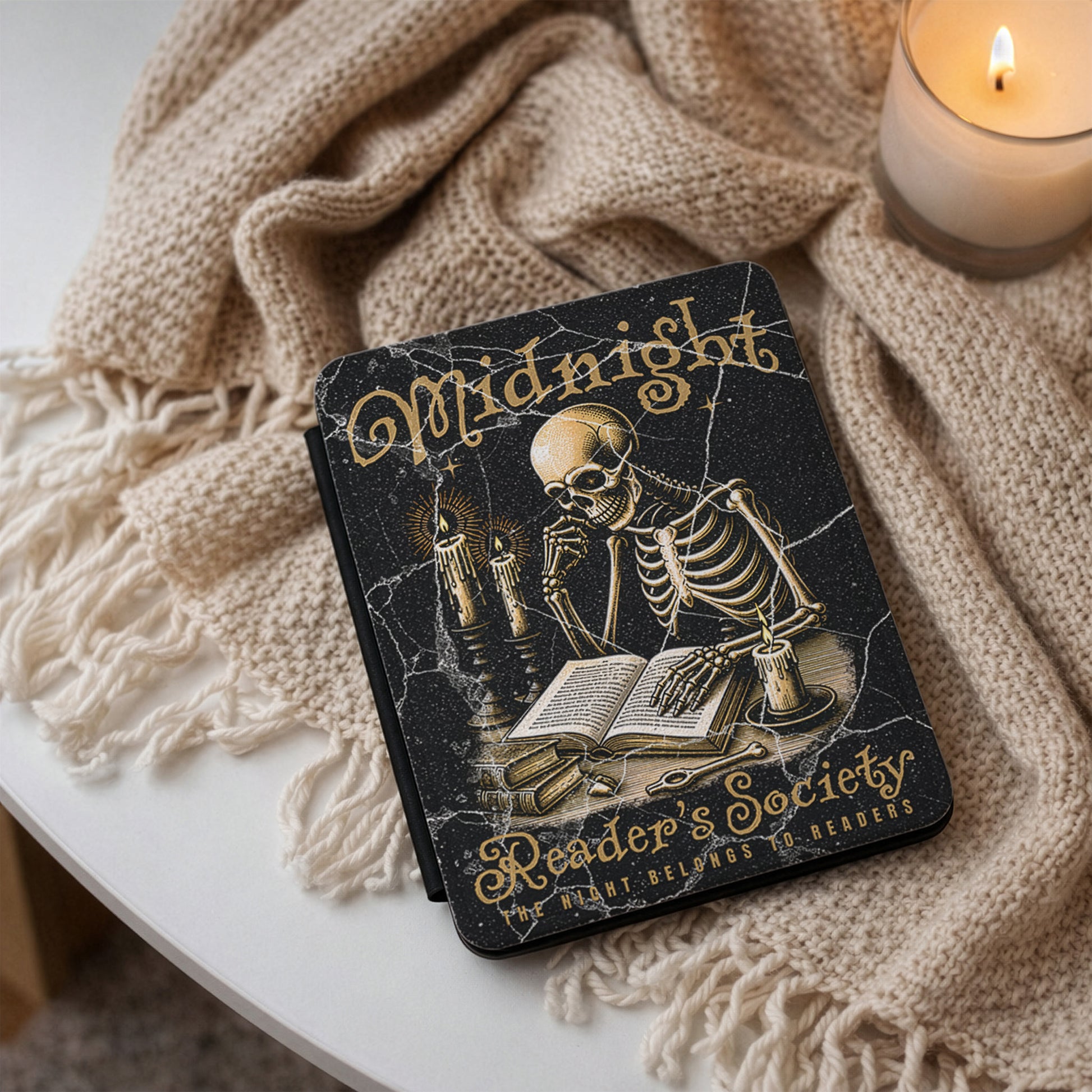 Kindle case 'Midnight Reader's Society' with a skeleton illustration on a textured surface with a candle.