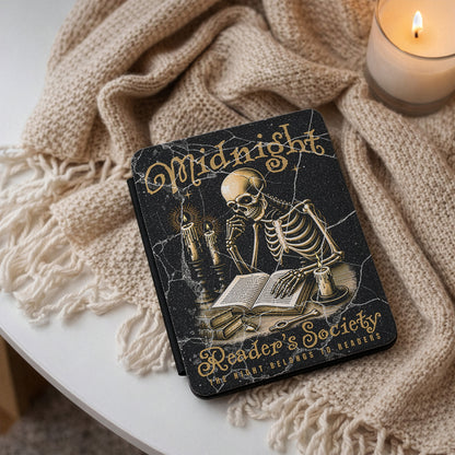 Kindle case 'Midnight Reader's Society' with a skeleton illustration on a textured surface with a candle.