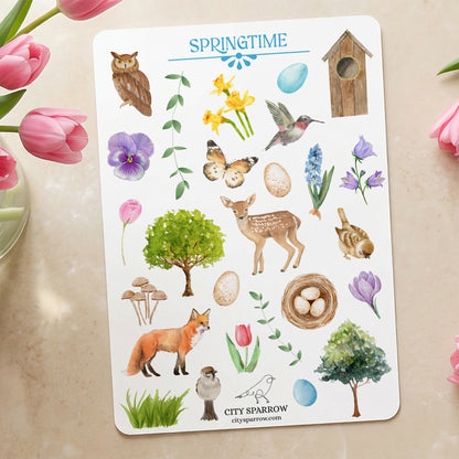 Sheet of spring-themed stickers with animals, flowers, and nature elements on a beige surface.