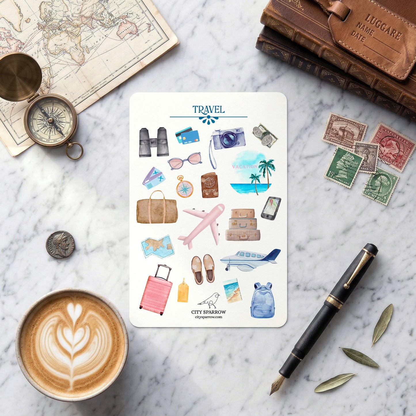 Travel-themed sticker sheet on a marble surface with coffee, pen, and decorative items.