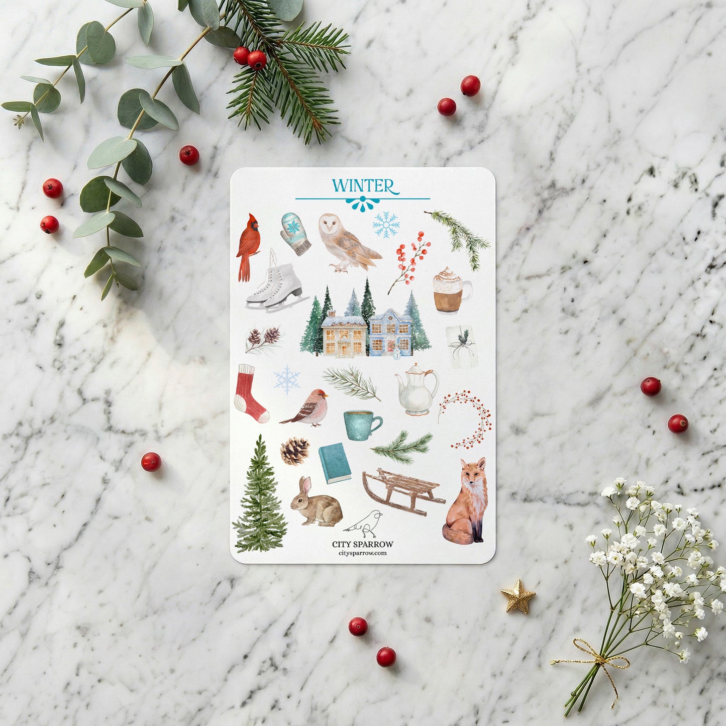 Sheet of winter-themed stickers on a marble surface with decorative elements.
