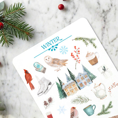 Sheet of winter-themed stickers with illustrations on a marble surface.